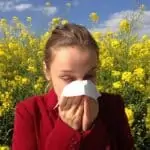 woman with allergies in a field of flowers